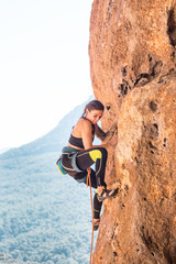 A girl climbs a rock.