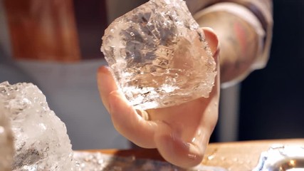 Barman is making brand ice for the cocktail at bar