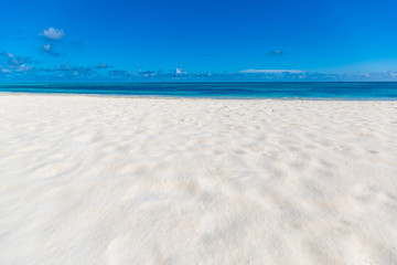Fototapeta na wymiar Empty beach scenery, white sand blue sky and blue sea. Tropical beach landscape background. Summer vacation and holdiay