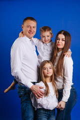 Beautiful happy family - isolated over a blue background 