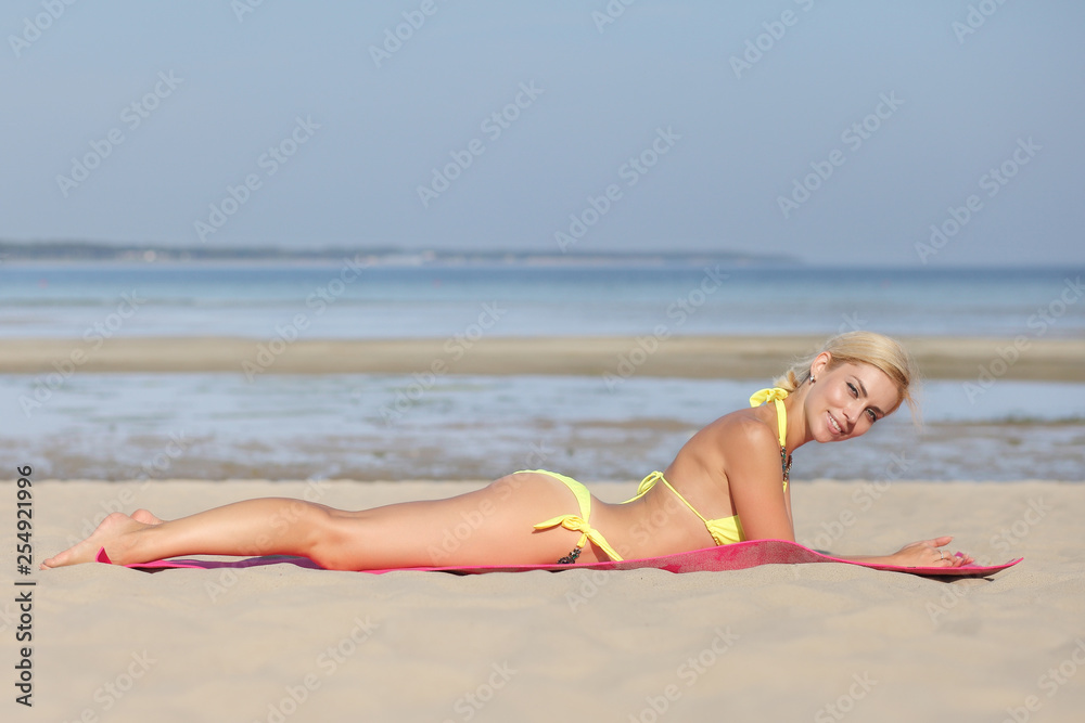 Wall mural woman on the beach with sand