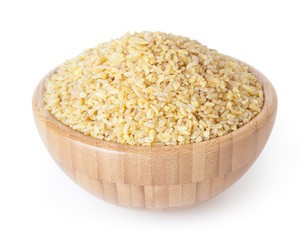 Uncooked bulgur in wooden bowl isolated on white background with clipping path