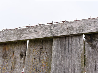 high fence with barbed wire on a white background.