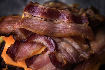 Homemade bacon burger on wooden tray.