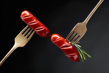 Grilled sausages with rosemary on a forks.