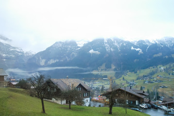 Fototapeta na wymiar 秋の雨の朝の雲が垂れ込めたグリンデルワルド（スイス・ベルン州・グリンデルワルト）