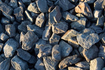mound of small and large crushed stones with golden light rays