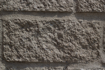 The background of a concrete wall in gray with an imitation of brickwork