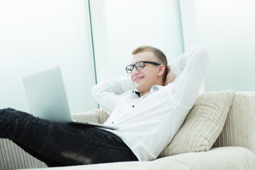 smiling man watching video on his laptop.
