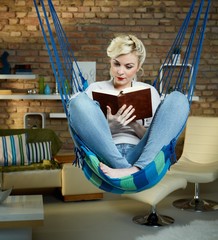 Young woman reading in hammock