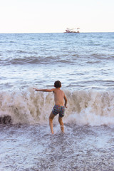 The boy frolics in the big waves