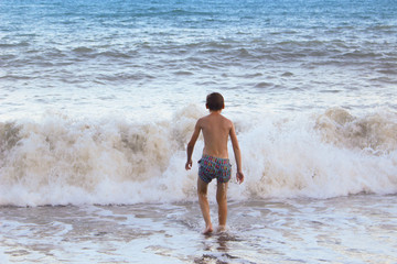 The boy frolics in the big waves