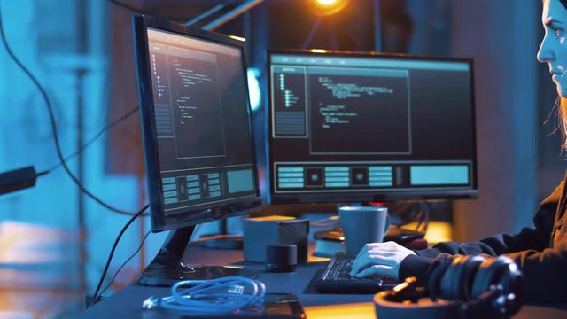 cybercrime, hacking and technology concept - female hacker in dark room creating code or using computer virus program for cyber attack