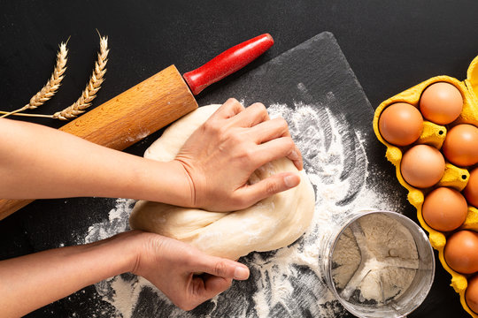 Food Preparation Concept Over Head Shot Kneading Dough For Bakery, Pizza Or Pasta On Black Background With Copy Space