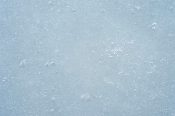 Ice with air bubbles of a gray blue shade. Textured abstract natural background