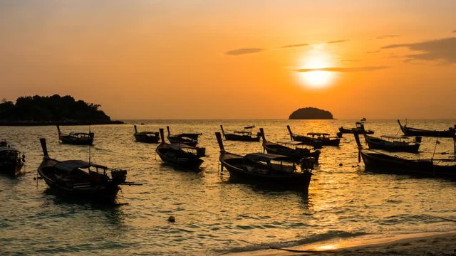 Time-lapse silhouette boats over sea at Koh Lipe during sunrise, sun moviing up , Zoom in.