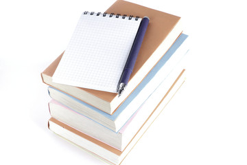 open the notebook, pen and a stack of books on white background