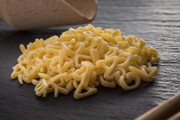 haufen roher Buchstabennudeln und Utensilien