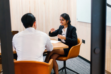 A perfect Indian lady sitting close by an assistant inside a gathering room. She is discussing some approach and looking flawless in her office attire.