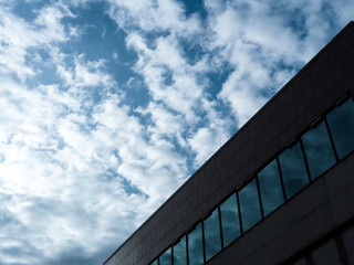 Blue sky and clouds reflected in windows of modern building