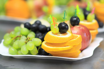 close up.plate with grapes and oranges on blurred background