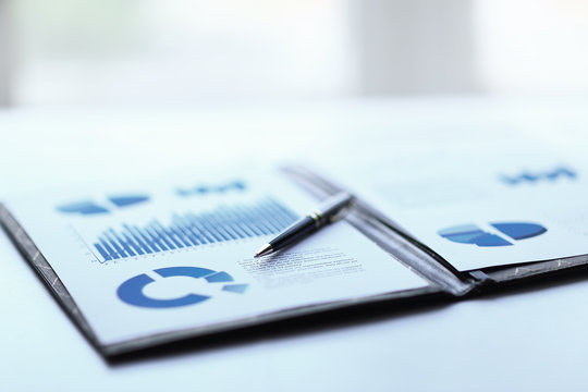 background image of a clipboard with financial report on table