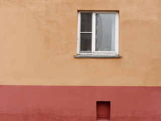 window of a high-rise building on a red basement wall