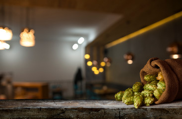 Beer brewing ingredients Hop in bag and wheat ears on wooden cracked old table. Beer brewery...