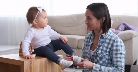 Cute baby daughter getting ready with her mother at home