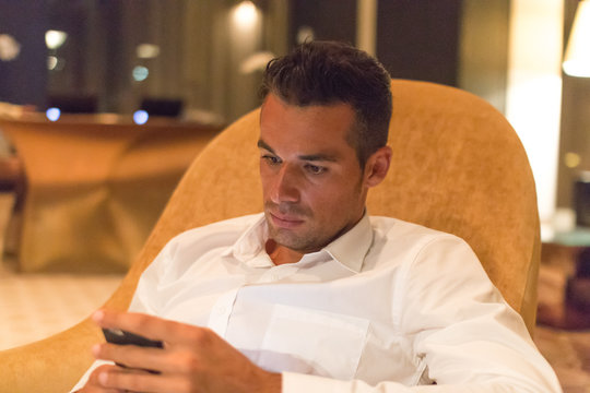 Junger Gesch&auml;ftsmann checkt seine Nachrichten auf einem Smartphone