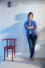 Casual woman standing against wall