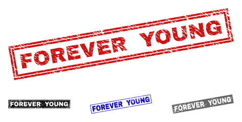 Grunge FOREVER YOUNG rectangle stamp seals isolated on a white background. Rectangular seals with distress texture in red, blue, black and gray colors.
