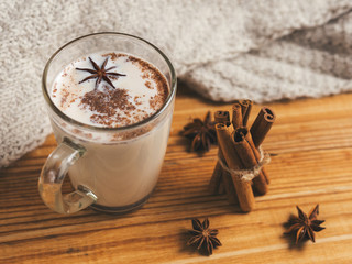 spicy masala tea with cinnamon and anise on wooden background