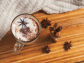 spicy masala tea with cinnamon and anise on wooden background