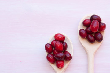 Raw cranberries and wooden spoon.