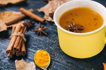 tea with turmeric, cinnamon, anise on a dark wooden table