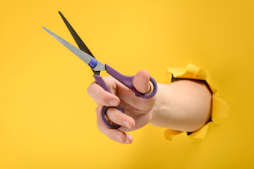 Hand holding scissors