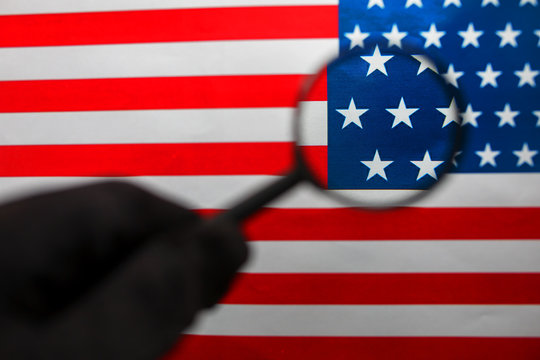 The American flag is viewed through a magnifying glass. Spies and surveillance USA concept. Control of the state of the United States
