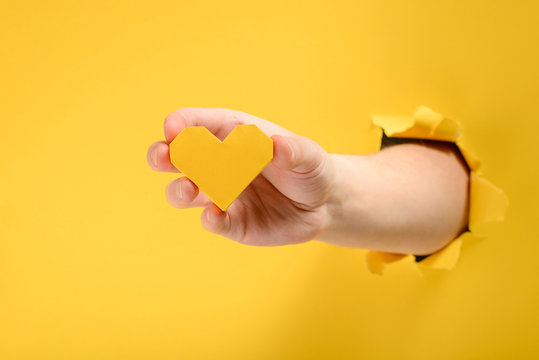 Hand giving a yellow heart