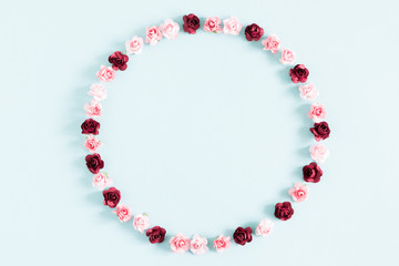 Flowers composition creative. Wreath made of purple and pink flowers on pastel blue background. Flat lay, top view, copy space