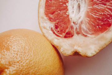 Halved grapefruit close up. Citrus fruit. Healthy eating. Pink color wallpaper. White background