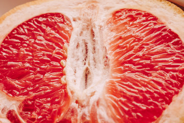 Halved grapefruit close up. Citrus fruit. Healthy eating. Pink color wallpaper. White background