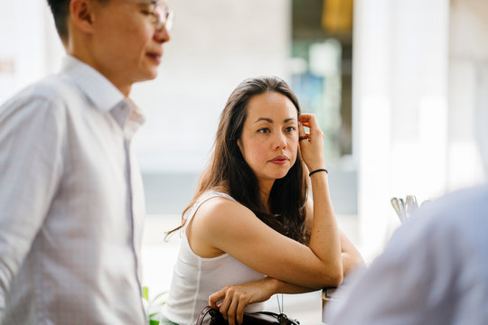 An Asian Business Team Consults One Other In A Meeting During The Day At The Office. Everyone Looks Professional In Their Outfit.