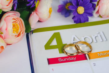 Gold Wedding ring on calendar planning or office tool.
