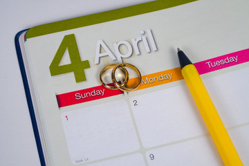 Gold Wedding ring on calendar planning or office tool.
