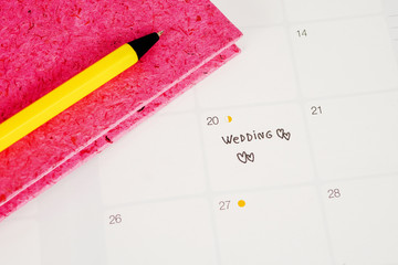 Word Wedding to Reminder Wedding day in calendar planning and pen with heart.