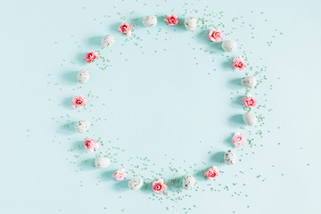 Easter decor, composition. Flowers, colored sugar, easter eggs on pastel blue background. Flat lay, top view, copy space
