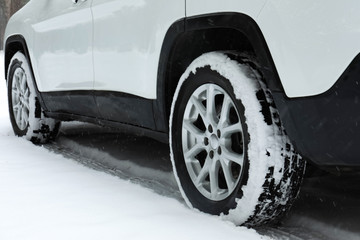 Modern car on snowy road, closeup view. Winter season