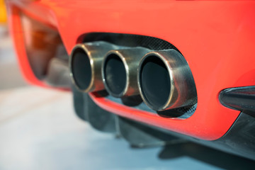 red sports car exhaust pipe.