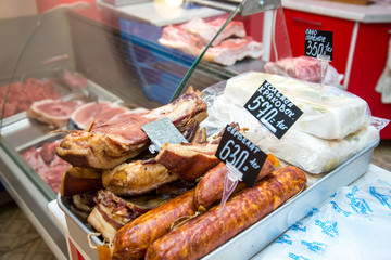 Big pile of whole bacon. Great smoked bacon. Smoked sausage. Salted lard. Inscription in Russian: smoked bacon, Krakow sausage